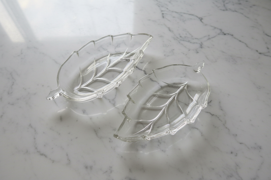 Clear glass leaf dishes set of 2 on white marble background